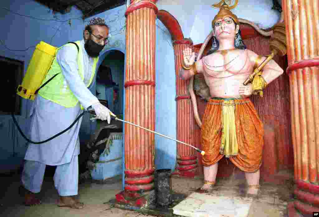 برای جلوگیری از شیوع ویروس کرونا، یک داوطلب مشغول ضدعفونی کردن یک معبد هندو در کراچی، پاکستان است.