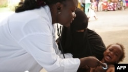 Une infirmière examine un enfant lors de tests de diagnostic de la pneumonie dans un centre de santé du quartier d'Attecoube à Abidjan, le 17 mars 2016.
