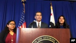 California Attorney General Xavier Becerra is flanked by Rosa Barrientos, of East Los Angeles, left, and Eva Jimenez, of Visalia, right, as he announces a lawsuit challenging the Trump administration's decision to end a program that shields young immigrants from deportation.