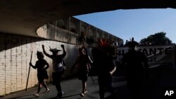 FILE - Indigenous people protest Brazilian President Jair Bolsonaro's proposals to allow mining on Indigenous lands in Brasilia, Brazil, June 16, 2021.