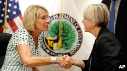 Education Secretary Betsy DeVos, left, shakes hands with Michelle Johnston, president of the University of Rio Grande, in Rio Grande, Ohio, after speaking with the media after a series of listening sessions about campus sexual violence, Thursday, July 13, 2017, in Washington. (AP Photo/Alex Brandon)