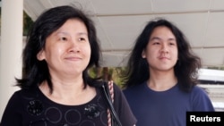 FILE - Teen blogger Amos Yee arrives with his mother at the State Courts in Singapore, Sept. 28, 2016. 