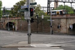 Pejalan kaki berjalan melewati pusat kota selama penguncian untuk mengekang penyebaran COVID-19 di Sydney, Australia, 30 September 2021. (Foto: REUTERS/Loren Elliott)