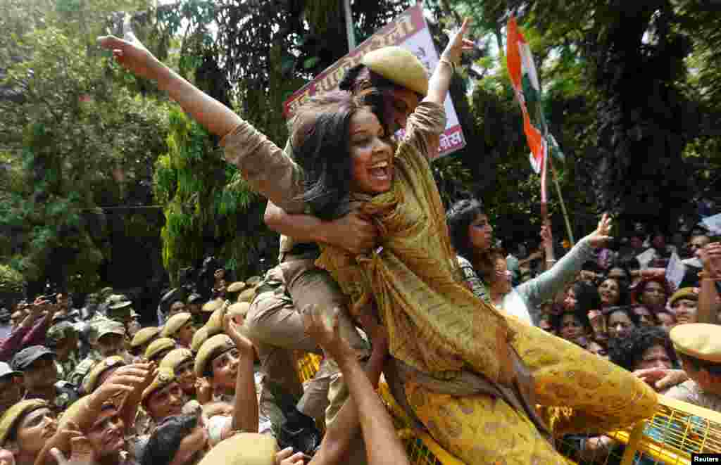 A policewoman tries to stop a member of the All India Mahila Congress, the women's wing of the Congress party, who was trying to cross over a barricade, during a protest against Indian Prime Minister Narendra Modi in New Delhi.