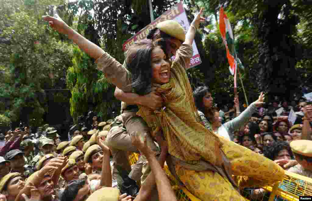 Uma policial segura um membro do &quot;All Índia Mahila Congress&quot; que estava tentando a atravessar&nbsp; uma barreira durante manifestações contra o Primero Ministro Indiano Narendra Modi em New Delhi, Índia, 21 de Julho, 2015.