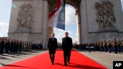 French President Emmanuel Macron, left, and his Chinese counterpart Xi Jinping attend a wreath laying ceremony at the Arc de Triomphe monument in Paris, March 25, 2019. 