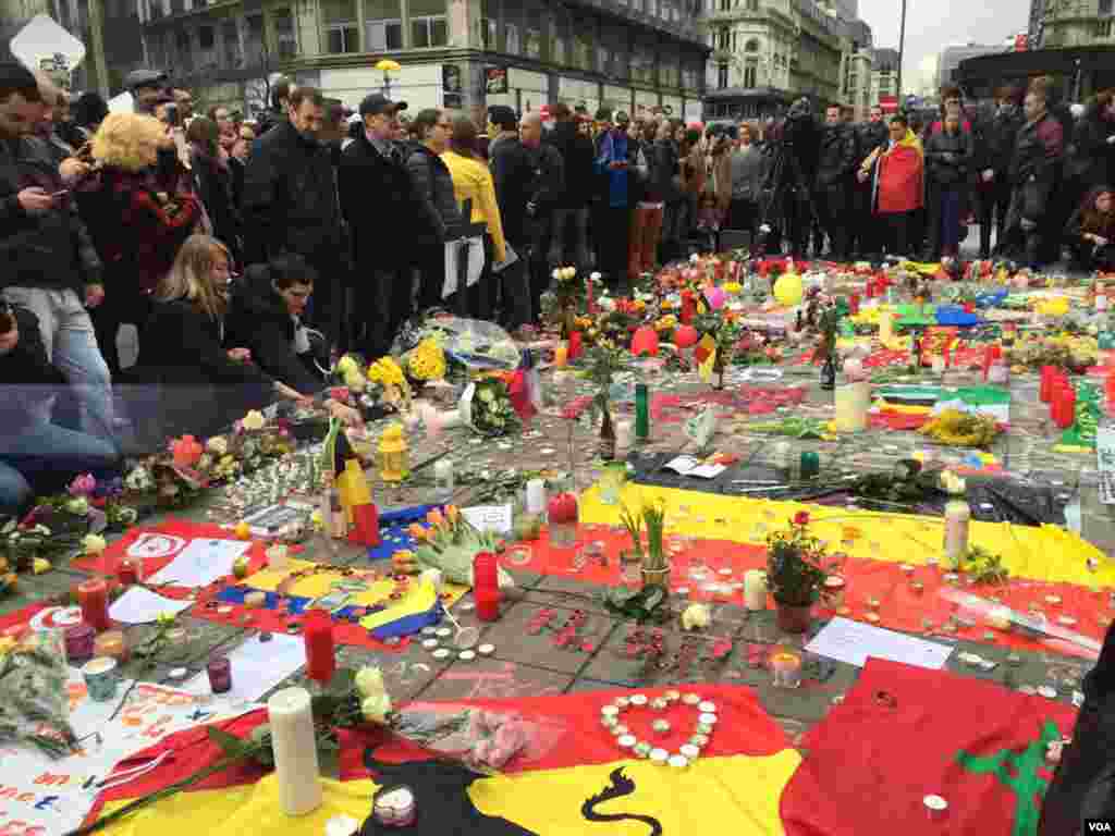 People gather around makeshift memorial in honor of terror attack victims in Brussels, Belgium, March 23, 2016. (N. Pourebrahim/ VOA)