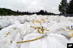 Bags of debris gathered off the coast are shown in Kodiak, Alaska, July 15, 2015. A barge will be used to haul away tons of marine debris — some likely from the 2011 tsunami in Japan — from Alaska shores.