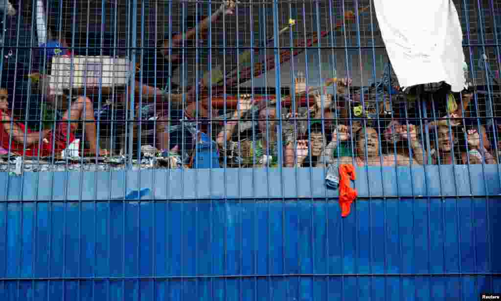 Detainees look out from a detention cell at a police station in Tondo, Manila, Philippines.