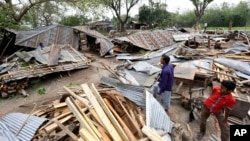 An April 5, 2015, photo shows Bangladeshi villagers inspecting the scene after tropical storms damaged houses in Gabtoli area, in northern Bogra district, Bangladesh.