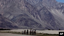 Beberapa turis menunggang unta di wilayah Ladakh, kawasan Jammu Kashmir, India, yang berbatasan dengan China (foto: dok). 