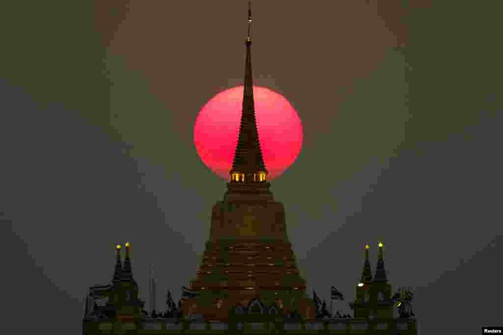 The sun sets behind Wat Saket Temple, or Golden Mount in Bangkok, Thailand, March 11, 2019