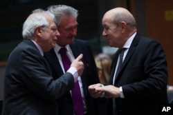 French Foreign Minister Jean-Yves Le Drian, right, speaks with Spanish Foreign Minister Josep Borrell, left, and Luxembourg's Foreign Minister Jean Asselborn during an EU Foreign Ministers meeting at the European Council headquarters in Brussels, Belgium, Feb. 18, 2019.