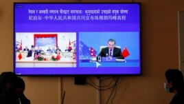 Nepalese government officers watch a live telecast of a joint announcement on the height of Mount Everest, in Kathmandu, Nepal, Tuesday, Dec. 8, 2020. China and Nepal have jointly announced on Tuesday, Dec. 8, 2020, a new height for Mount Everest, ending