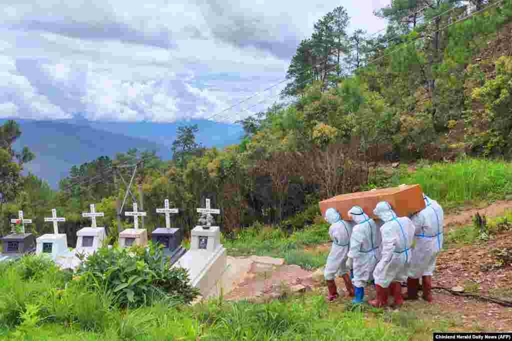 Health workers in protective suit carry a coffin of the body of a Covid-19 coronavirus patient during a burial at a cemetery in Falam township in western Myanmar's Chin state. 