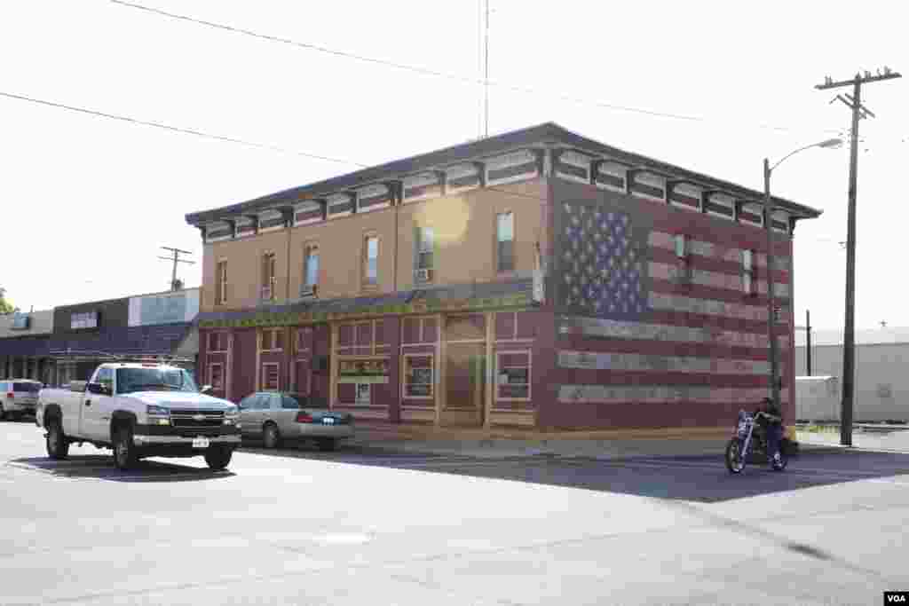 Sebuah bangunan di jalan utama yang memiliki lukisan bendera Amerika di salah satu sisinya di kota Plano, Illinois. (VOA/K. Farabaugh)