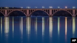 El puente Francis Scott Key, entre Rosslyn y Georgetown, en Washington se refleja en el río Potomac cuya superficie continúa congelada.