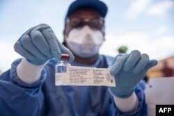 A nurse working with the WHO shows a bottle containing Ebola vaccine in Mbandaka on May 21, 2018.