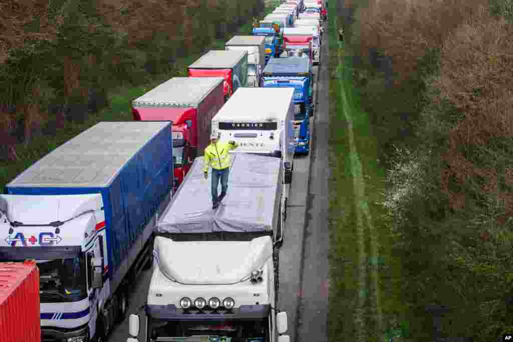 Drivers stand among trucks on the E411 highway from Brussels to Luxembourg as they protest against road charging, near Spontin, Belgium.