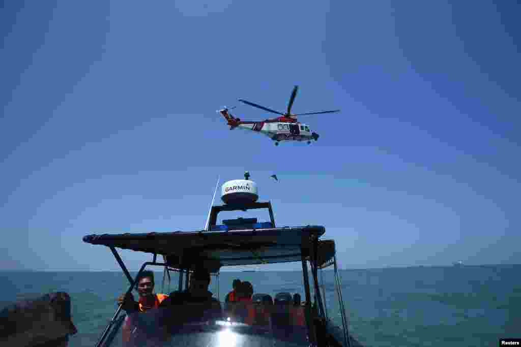 Sebuah helikopter Malaysia terlihat sedang melakukan operasi pencarian dan penyelamatan di perairan barat Malaysia (18/6).