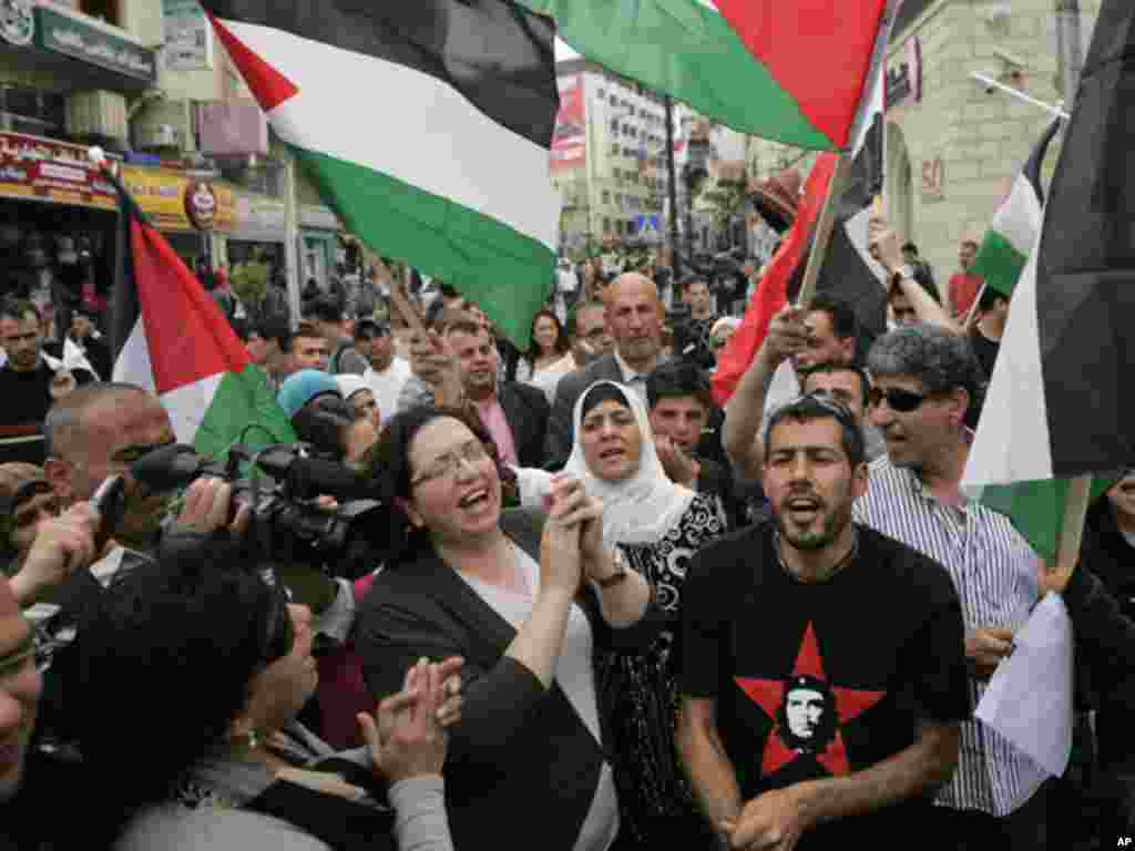 Palestinians wave flags and chant during a rally celebrating the planned signing of a reconciliation agreement between Fatah and Hamas, in the West Bank city of Ramallah, May 4, 2011. (AP)