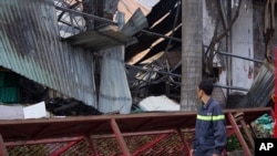 A man looks at the damaged building of Taiwanese bicycle factory Tan Than in Di An Town, Binh Duong Province, Vietnam, Wednesday, May 14, 2014.