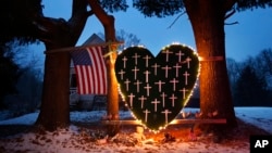 FILE - A makeshift memorial with crosses for the victims of the Sandy Hook Elementary School shooting massacre stands outside a home in Newtown, Conn., on the one-year anniversary of the shootings, Dec. 14, 2013.
