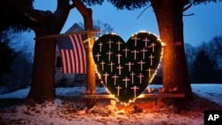 FILE - A makeshift memorial with crosses for the victims of the Sandy Hook Elementary School shooting massacre stands outside a home in Newtown, Conn., on the one-year anniversary of the shootings, Dec. 14, 2013.