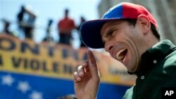 El líder opositor Enrique Capriles habla con un periodista durante un mitin en Caracas, Venezuela. (AP fotos).