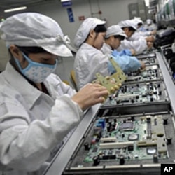 Chinese workers assemble electronic components at the Taiwanese technology giant Foxconn's factory in Shenzhen, Guangzhou province (File)