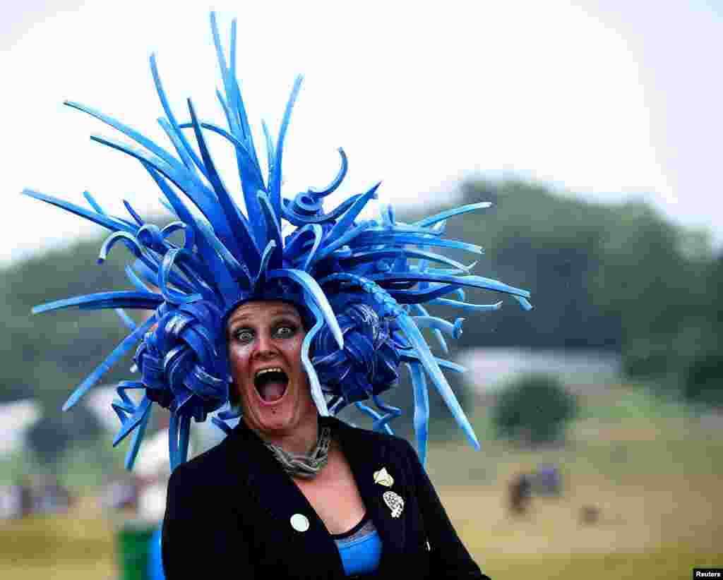 Um participante sorri ao andar na chuva na Fazenda &quot;Worthy&quot; em Somerset durante o Festival &quot;Glastonbury&quot; em Bretanha, 28 de Junho, 2015.