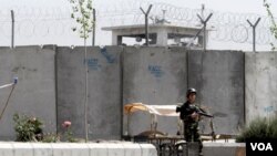 Tentara berjaga-jaga di depan penjara utama di kota Kandahar di Afghanistan selatan yang berhasil dibobol lewat bawah tanah.