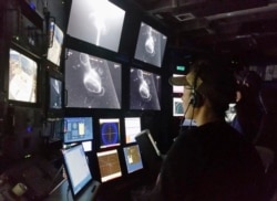 In this 2015 photo provided by the Monterrey Bay Aquarium Research Institute, Kakani Katija works in the remote operated vehicle control room on MBARI’s research vessel Western Flyer as the DeepPIV system illuminates a giant larvacean. (Kim Reisenbichler/