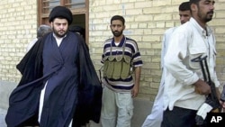 Shiite cleric Muqtada al-Sadr (L) - whose political party called December 26, 2011, for dissolution of Iraq's parliament and new elections in another move that could escalate country's growing sectarian crisis - steps from an office building in Najaf, Ira