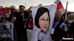 Members of the Taiwanese community in Paraguay hold up an image of Taiwan's President Tsai Ing-wen upon her arrival for the Aug. 15 ceremony at the Silvio Pettirossi International Airport in Luque, Paraguay, Aug. 14, 2018.