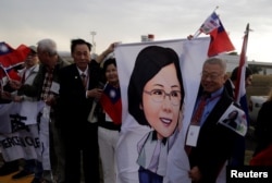 FILE - Members of the Taiwanese community in Paraguay hold an image of Taiwan's President Tsai Ing-wen upon her arrival at the Silvio Pettirossi International Airport in Luque, Paraguay, Aug. 14, 2018.