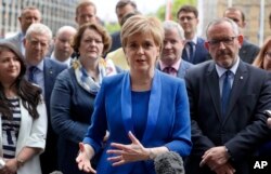 FILE - Nicola Sturgeon, First Minister of Scotland and the leader of the Scottish National Party talks to the media as she meets new SNP Members of Parliament in Parliament Square, Westminster, London, June 12, 2017.