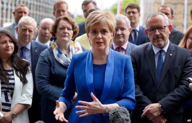 FILE - Nicola Sturgeon, first minister of Scotland and leader of the Scottish National Party, talks to the media as she meets new SNP Members of Parliament in Parliament Square, Westminster, London, June 12, 2017.
