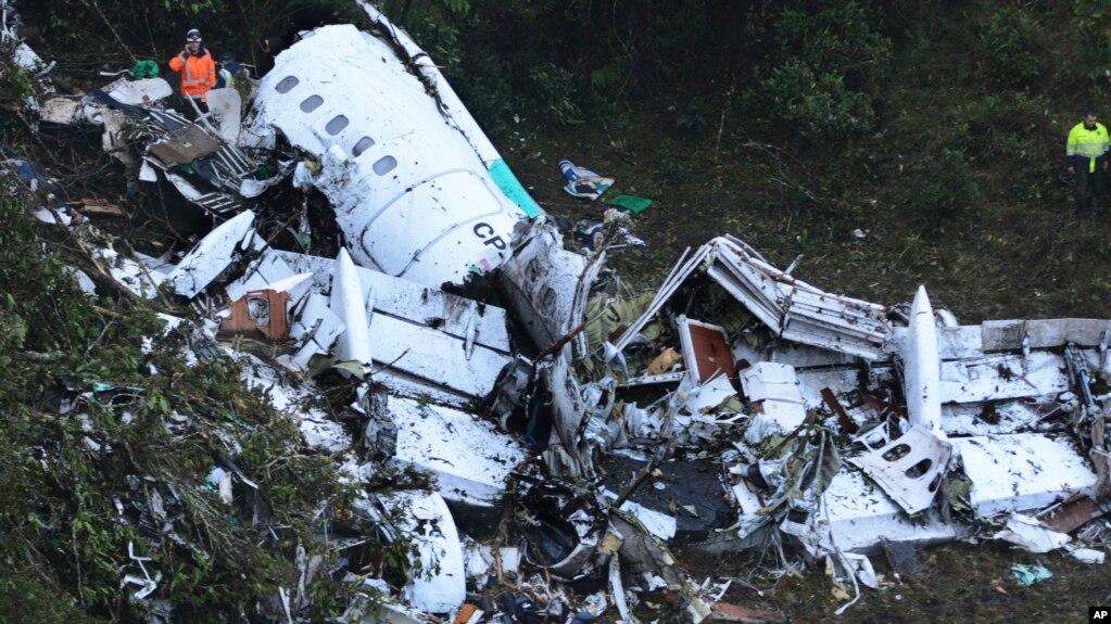 Seorang petugas penyelamat berdiri di dekat rongsokan pesawat yang jatuh di Medellin, Kolombia hari Selasa (29/11). Hanya 5 penumpang yang ditemukan selamat dalam kecelakaan ini.