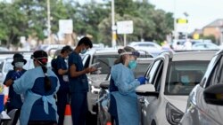 Petugas kesehatan melakukan tes PCR COVID-19 di St Vincent's Drive-through Clinic di Bondi Beach, Sydney, Sabtu, 1 Januari 2022.