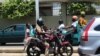 Un conducteur de moto remorquant 3 passagers à Lomé, le 14 août 2019. (VOA/Kayi Lawson)