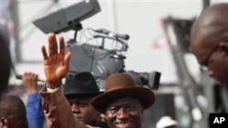Nigeria President Goodluck Jonathan, center, wave to his supporters during the final campaign rally, at Eagle Square in Abuja, March 26, 2011