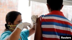 在秘魯與委內瑞拉邊境，一名秘魯醫護人員在給移民工人打疫苗針。（2019年6月14日）