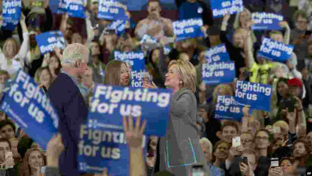 Hillary Clinton embrasse son mari, l'ancien président Bill Clinton, et sa fille, Chelsea Clinton, lors d'un rassemblement à Abraham Lincoln High School à Des Moines, Iowa, 31 janvier 2016.