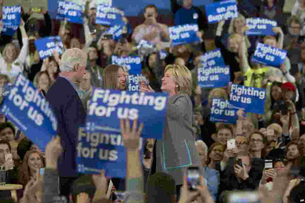 Democratic presidential candidate Hillary Clinton hugs her husband, former President Bill Clinton, and daughter, Chelsea Clinton, during a rally at the Abraham Lincoln High School in Des Moines, Iowa, Jan. 31, 2016.