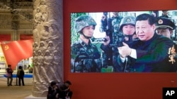 A video showing Chinese President Xi Jinping handling an assault rifle is shown at an exhibition highlighting China's achievements under five years of his leadership at the Beijing Exhibition Hall in Beijing, , Oct. 19, 2017.