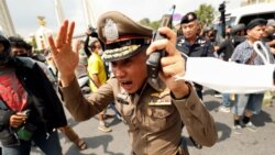 ຕໍາຫຼວດໄທຄົນນຶ່ງ ມີປະຕິກິລິຍາຕໍ່ການປະທ້ວງ ລະຫວ່າງພວກສະໜັບສະໜູນປະຊາທິປະໄຕ ແລະພວກຈົງຮັກພັກດີ ຕໍ່ລັດຖະ ບານ ວັນທີ 15 ຕຸລາ 2020. 