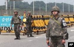 South Korean army soldiers stand guard at Unification Bridge near the border village of Panmunom in Paju, South Korea, Aug. 21, 2015.