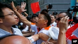 Pro-Beijing supporters (C and R) clash with pro-democracy protesters (L) during a rally to promote the Hong Kong electoral reform in Hong Kong, April 25, 2015.