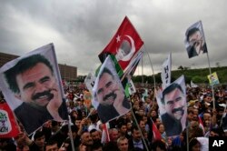 FILE - Supporters of the pro-Kurdish Peoples' Democratic Party, (HDP) wave a flag, center, with Turkish Republic founder Mustafa Kemal Ataturk, and others of imprisoned Kurdish rebel leader Abdullah Ocalan, during a rally in Istanbul, Turkey.